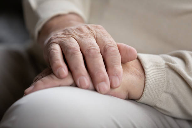 istock Elderly male sitting alone keeping wrinkled hands folded on knees 1311337319