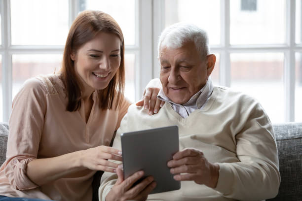 papá anciano compartiendo éxito en trabajar en la almohadilla con su hija - men middle senior adult human age fotografías e imágenes de stock