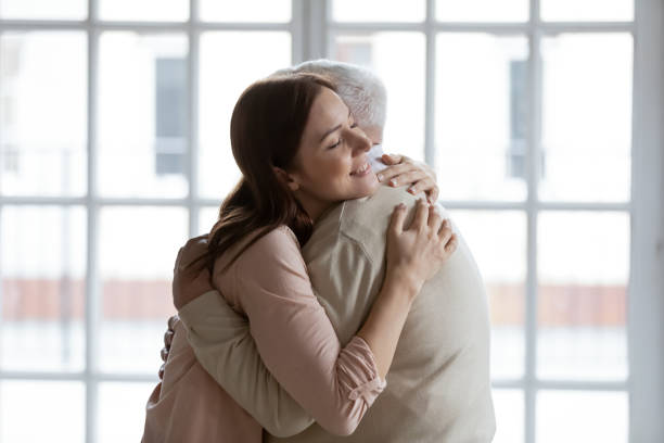 Grownup daughter cuddling senior dad meeting after long time separation Grownup daughter straining to heart dear senior dad meeting after long time separation. Tender young woman adult grandkid cuddling with warmth elderly man grandfather greeting with birthday father day father daughter 80s stock pictures, royalty-free photos & images