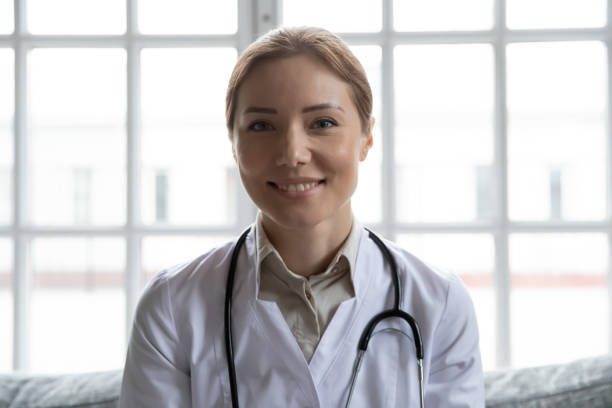 istock Friendly woman physician looking at web camera consulting patient online 1311337377