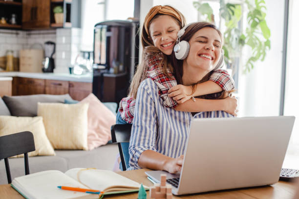 istock Employed mother working from home and her daughter embracing her 1311338624