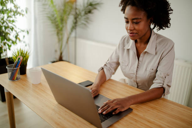 istock Concentrated afro american copywriter updating software on laptop computer in office. 1311340452