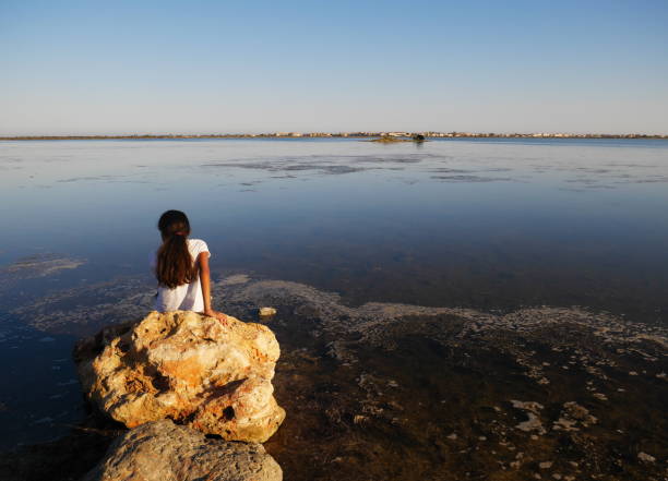 istock Girl seen from behind looking at the pond 1311340798