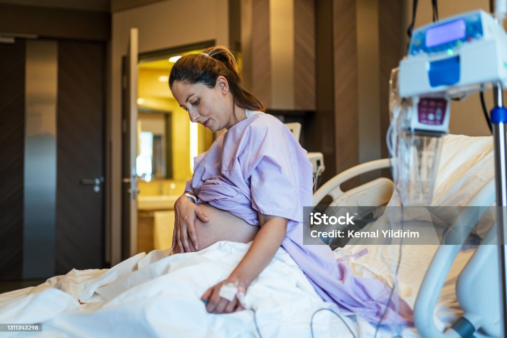 Young pregnant woman in the hospital ward and ready to delivery a baby. Labor - Childbirth Stock Photo