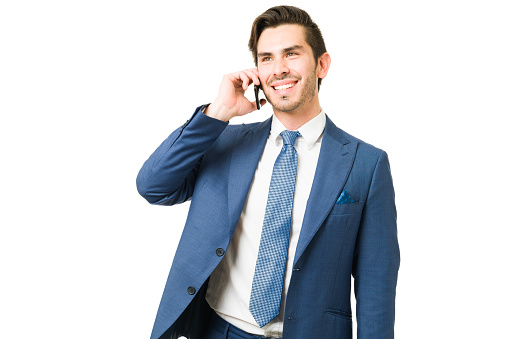 Attractive lawyer in a professional suit talking with a client on the phone. Happy businessman smiling while speaking with a coworker with his smartphone