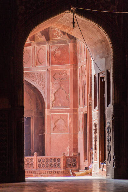 istock AGRA, INDIA - FEBRUARY 19, 2017: Local man sitting under an arch at Taj Mahal complex in Agra, Ind 1311348022