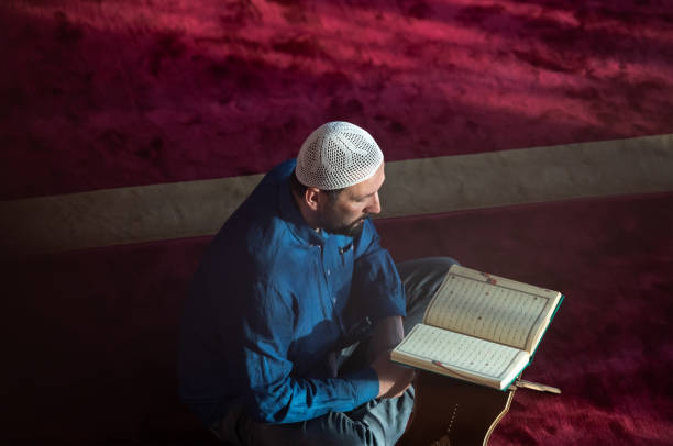 istock muslim man praying Allah alone inside the mosque and reading islamic holly book 1311348933