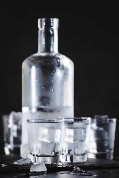 istock Cold Vodka in shot glasses on black background, ready to drink 1311350036
