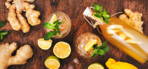ginger ale cocktail con birra, lime, limone e menta in glaass su tavolo di legno, striscione con vista dall'alto - ginger tea root hot drink foto e immagini stock