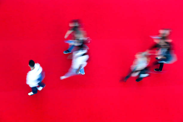 istock Crowd of Blurred People Walking Fast on Red Carpet 1311350129