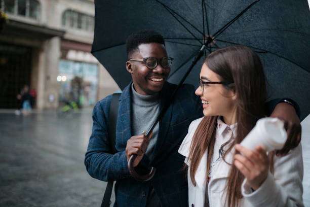 istock Happy diverse couple walking on a rainy day 1311351842