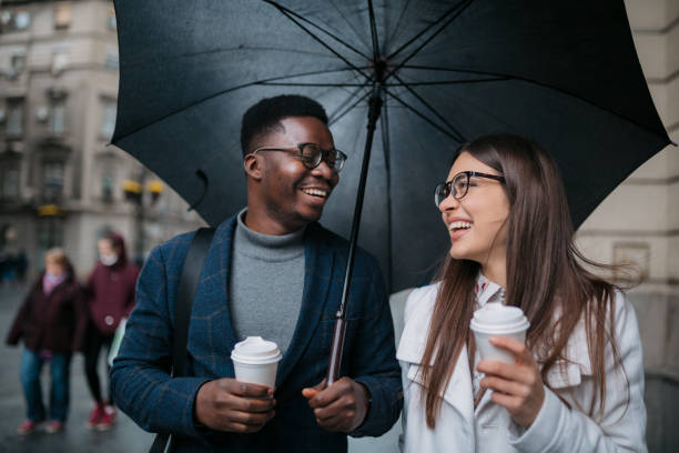 istock Happy diverse couple walking on a rainy day 1311351847
