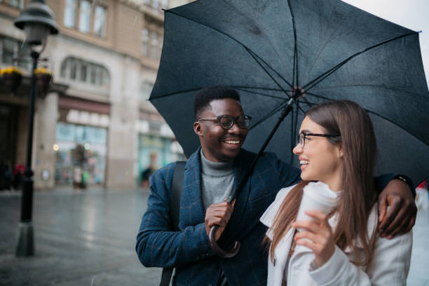 istock Happy diverse couple walking on a rainy day 1311351903