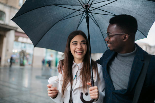istock Happy diverse couple walking on a rainy day 1311351954
