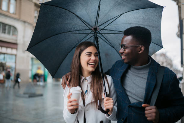 istock Happy diverse couple walking on a rainy day 1311352757