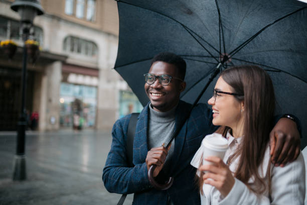 istock Happy diverse couple walking on a rainy day 1311353193