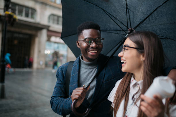 istock Happy diverse couple walking on a rainy day 1311353330