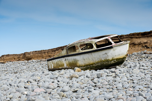 Ship wreck of an old boat washed up on a rocky beach