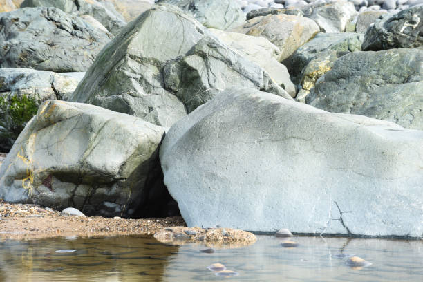 istock Large stone boulder formation with reflections in water 1311354179
