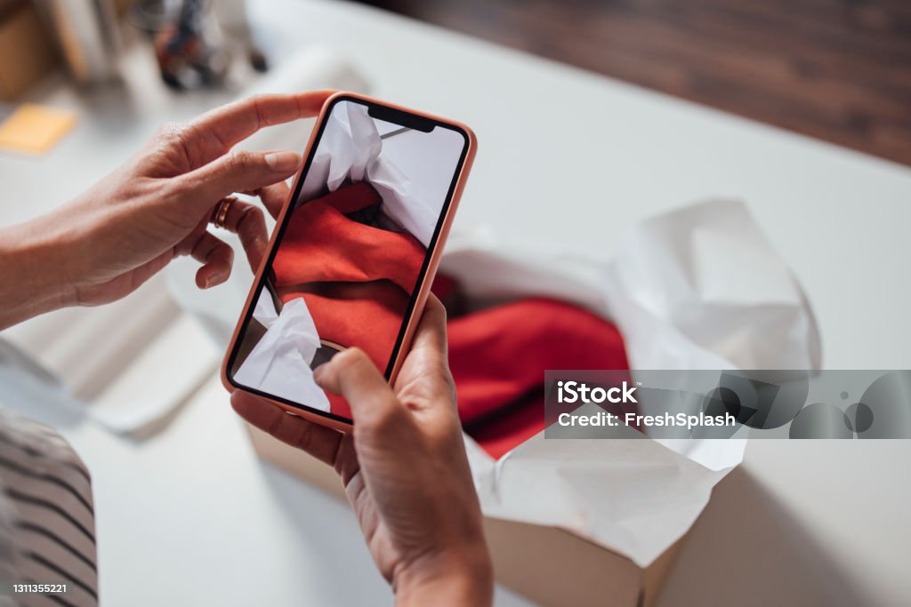 Anonymní majitel malého online obchodu s oblečením a obuví, který fotografuje zboží před odesláním - Bez autorských poplatků Oděv - Člověkem Stock fotka Anonymní majitel malého online obchodu s oblečením a obuví, který fotografuje zboží před odesláním - Bez autorských poplatků Oděv - Člověkem Stock fotka