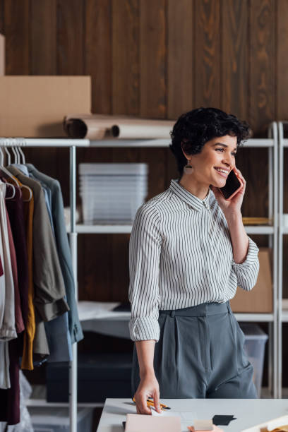istock Happy Online Clothes Store Owner Talking on Her Cell Phone 1311355225