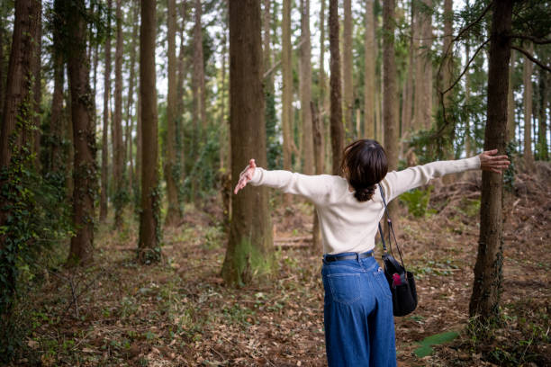istock Young woman deep breathing in forest 1311357801