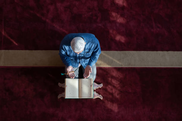 istock muslim man praying Allah alone inside the mosque and reading islamic holly book 1311360165