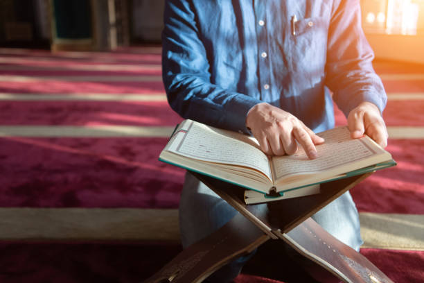 istock muslim man praying Allah alone inside the mosque and reading islamic holly book 1311362174