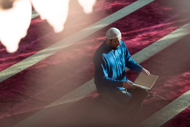 istock muslim man praying Allah alone inside the mosque and reading islamic holly book 1311362949
