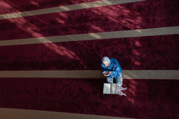 istock muslim man praying Allah alone inside the mosque and reading islamic holly book 1311364574