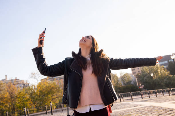 istock joyful woman laughing and dancing with the phone 1311367681
