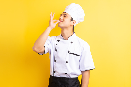 Image of Asian male chef on yellow background