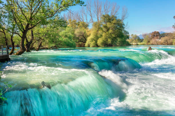 hermoso paisaje natural de la cascada de manavgat en el parque nacional en el soleado día de primavera. color azul único del agua con salpicaduras, side, antalya, turquía - water waterfall sky seascape fotografías e imágenes de stock