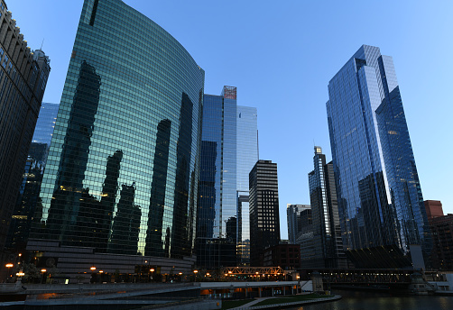 Tranquil dusk in downtown Chicago with a clear, blue sky over Chicago River waterfront.