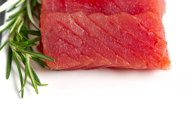 istock Raw tuna slice with rosemary on the white background with copy space 1311382407