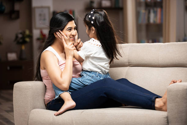 joyful mother cuddling and playing with cute girl at home, - facial expression child asia asian and indian ethnicities imagens e fotografias de stock