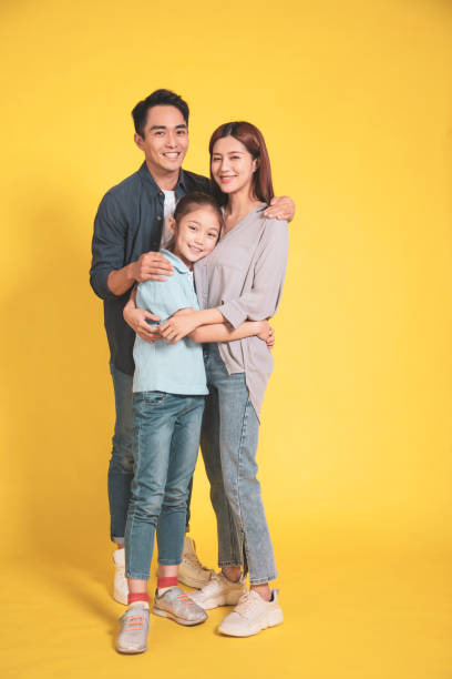 família jovem asiática feliz com uma criança em pé abraçando e sorrindo - holding men casual mother - fotografias e filmes do acervo