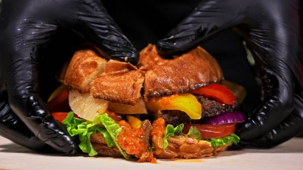 istock Cut craft burger is cooking. Consist: red sauce salsa, lettuce, red onion, pickle, cheese, chilli green pepper, air bun and marbled meat beef. 1311385123