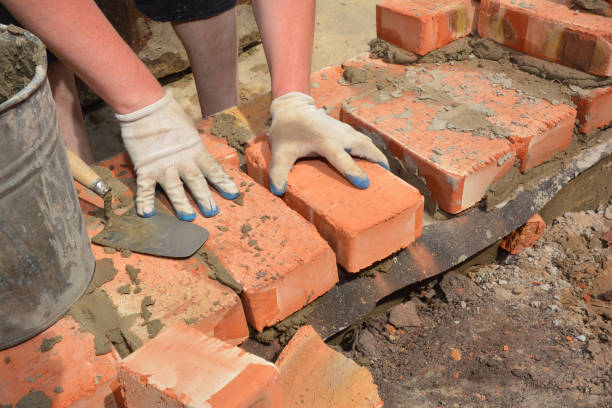 istock A bricklayer is laying the first row of bricks on a concrete foundation or footing above a damp proof course, a layer of impermeable bitumen barrier to prevent ground water upward migration. 1311391241