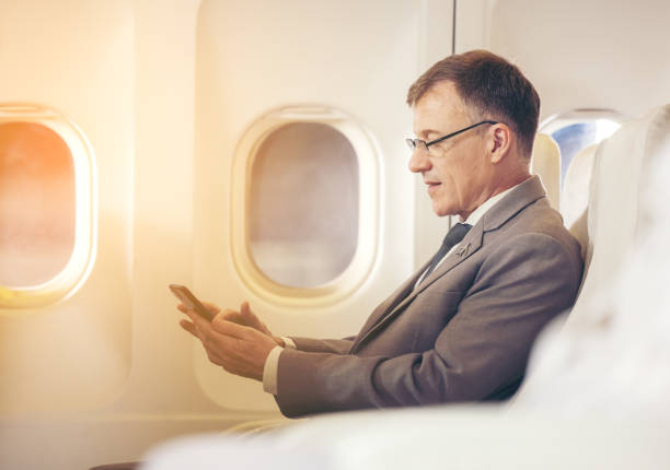 istock businessman with suit sitting seat via using smartphone in the airplane 1311392036