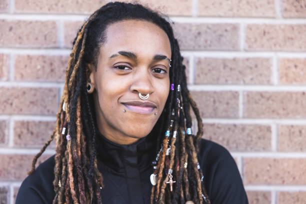 Androgynous Person Portrait A portrait of an androgynous African American person on a brick background. septum piercing stock pictures, royalty-free photos & images