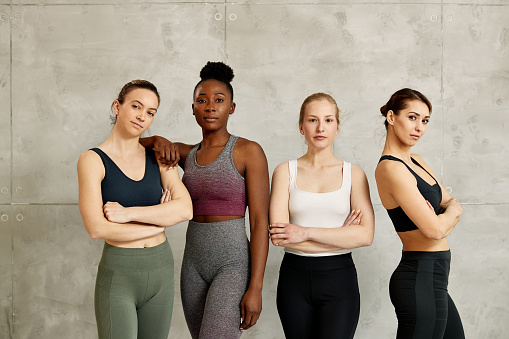 Portrait of confident multi-ethnic group of sportswomen against the wall. Copy space.