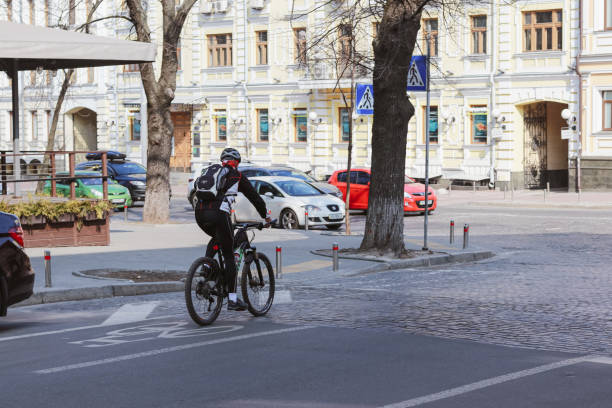 w mieście blokady. rowerzyści i nieliczni piesi chodzą pustymi ulicami. - unmasked zdjęcia i obrazy z banku zdjęć