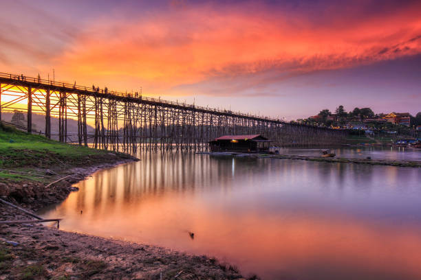 la rivière et le vieux pont en bois (pont de mon) dans le beau ciel avec le nuage avant le coucher du soleil à sangklaburi, province de kanchanaburi, thaïlande - asia kanchanaburi province lake nature photos et images de collection