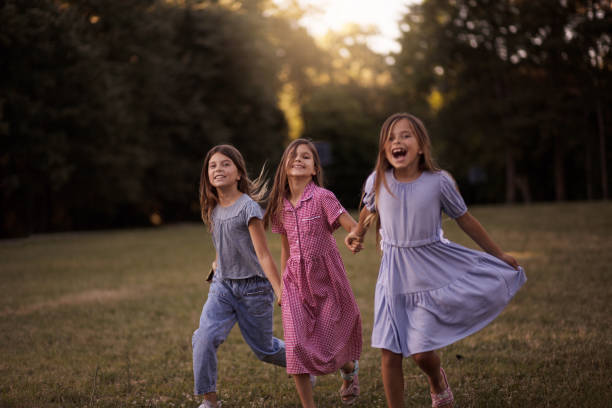Smiling kids. Three little girls together in nature. Running.