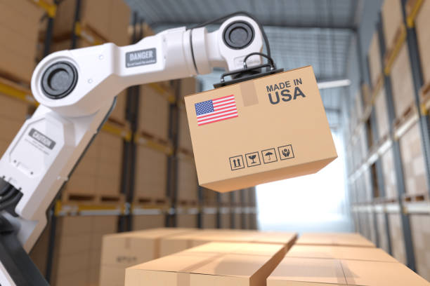 the robot arm picks up the cardboard box made in usa, automation robot arm in the storehouse - made in the usa imagens e fotografias de stock