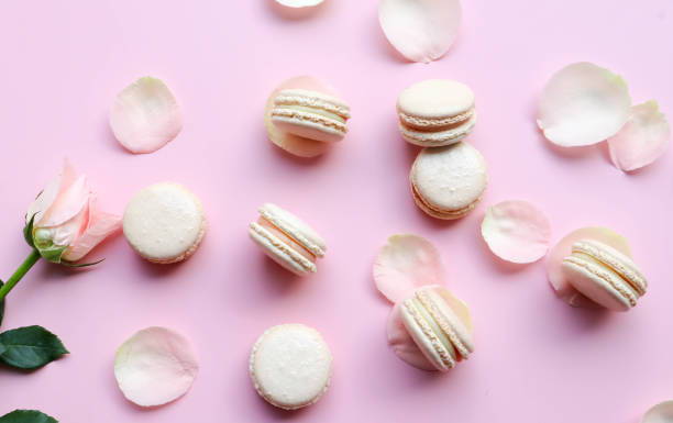 istock Pink Macarons and rose petals flat lay on pink background 1311395185