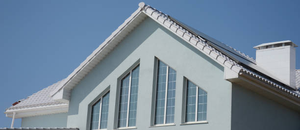 istock Exterior view of a triangular window design, irregular shape windows of the second level space, loft or attic of a light blue modern house with solar panels, a white chimney on a white roof. 1311396072