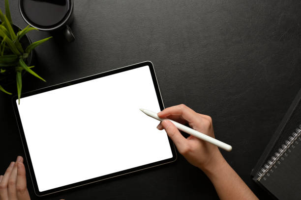 istock Top view of female hand using digital tablet screen on dark creative workspace 1311396253