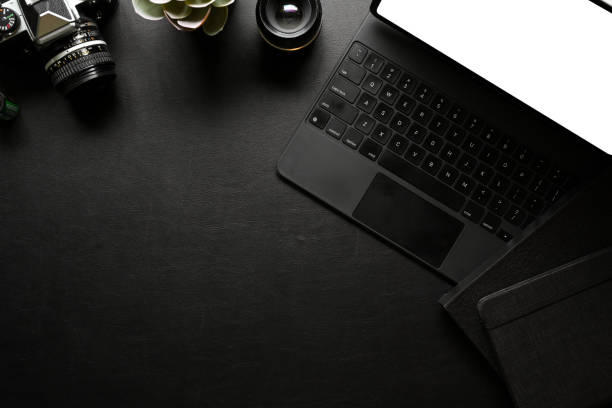istock Creative workspace with digital tablet, accessories, camera, supplies and copy space on black table 1311396284